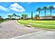 Gated community entrance with landscaped features, brick-paved road, and decorative signage at 5126 Villa Crest Way, Auburndale, FL 33823