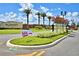 Community entrance featuring well-maintained landscaping, palm trees, and decorative streetlights at 5126 Villa Crest Way, Auburndale, FL 33823
