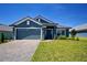 Beautiful single-story home with a well-manicured lawn, brick paver driveway, and a two-car garage at 5126 Villa Crest Way, Auburndale, FL 33823