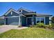 Inviting exterior of a modern home featuring a dark blue facade, tiled roof, and a lush green lawn at 5126 Villa Crest Way, Auburndale, FL 33823