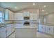 Modern kitchen with white cabinets, granite countertops, stainless steel appliances, and a kitchen island at 5126 Villa Crest Way, Auburndale, FL 33823
