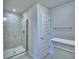 Modern bathroom shower with glass door and gray tiling, with an adjacent towel rack at 5126 Villa Crest Way, Auburndale, FL 33823