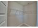 Walk-in closet features a series of white shelving and bars for ample storage space at 5126 Villa Crest Way, Auburndale, FL 33823