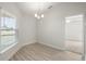 Dining area features wood floors and a chandelier with view to adjacent room at 1365 Melrose St, Lake Alfred, FL 33850
