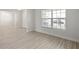 Open-concept living area with modern wood flooring and natural light with view to entryway at 1365 Melrose St, Lake Alfred, FL 33850