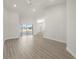 Bright and airy living room featuring wood-look floors and sliding glass doors at 1365 Melrose St, Lake Alfred, FL 33850