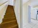 View of wooden staircase with white banister leading to upper level with access to the kitchen area at 1836 N Crystal Lake Dr # 46, Lakeland, FL 33801