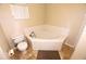 Corner soaking tub in a well-lit bathroom with tile floors and a neutral color palette at 2556 Roslyn Ln, Lakeland, FL 33812