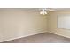 This carpeted bedroom is bright, with a ceiling fan and large window at 2556 Roslyn Ln, Lakeland, FL 33812