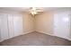 This bedroom has neutral walls, carpet, a ceiling fan, and a double-door closet for ample storage at 2556 Roslyn Ln, Lakeland, FL 33812