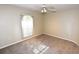 Neutral carpeted bedroom with a large window and ceiling fan for air circulation at 2556 Roslyn Ln, Lakeland, FL 33812