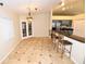 Dining area with French doors and kitchen bar access, featuring tile floors and overhead lighting at 2556 Roslyn Ln, Lakeland, FL 33812