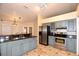 Well-equipped kitchen with stainless steel appliances, light blue cabinets, and dark countertops at 2556 Roslyn Ln, Lakeland, FL 33812