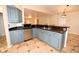 Kitchen featuring updated appliances, stylish blue cabinets, and tile flooring at 2556 Roslyn Ln, Lakeland, FL 33812