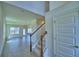 Welcoming entryway showcasing wood-trimmed staircase, light gray wood-look flooring and an open floor plan at 4712 Grandview Glen Dr, Auburndale, FL 33823