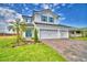 Beautiful two-story home boasts a three-car garage, manicured lawn, vibrant landscaping, and modern design at 4712 Grandview Glen Dr, Auburndale, FL 33823