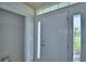 Bright foyer area with a coat closet and a view of a palm tree through the sidelight window at 4712 Grandview Glen Dr, Auburndale, FL 33823