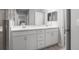 Bathroom featuring double sink vanity with white cabinets and modern fixtures and door to bedroom at 5335 Se 127Th Ln, Belleview, FL 34420