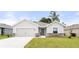 Charming single-story home features a well-manicured lawn, stone accents, and a two-car garage at 5335 Se 127Th Ln, Belleview, FL 34420