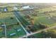 Aerial view of a large property with farmlands, a home, and lakes at 6155 Bethlehem Rd, Mulberry, FL 33860