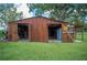 Exterior view of a wooden garage with open doors on a green lawn at 6155 Bethlehem Rd, Mulberry, FL 33860