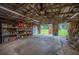 Spacious garage interior featuring concrete floors and a practical storage and refrigerator at 6155 Bethlehem Rd, Mulberry, FL 33860