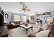 Comfortable living room with ceiling fans, wood-look floors, and a cozy fireplace, ideal for relaxing and entertaining at 6155 Bethlehem Rd, Mulberry, FL 33860