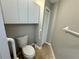 Compact bathroom featuring a toilet, storage cabinet, and safety bar at 6718 Trail Ridge Dr, Lakeland, FL 33813