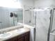 Modern bathroom with double sink vanity, glass shower, and elegant marble-like tile at 6799 Glenbrook Dr, Lakeland, FL 33811
