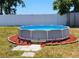 An above-ground pool surrounded by red mulch, set against a white fence backdrop at 3136 Country Club Cir, Winter Haven, FL 33881