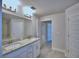 Bright bathroom featuring a double sink vanity with granite counters and a large mirror at 4639 Grandview Glen Dr, Auburndale, FL 33823