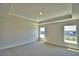 Spacious bedroom with neutral carpet, tray ceiling, and two windows letting in natural light at 4639 Grandview Glen Dr, Auburndale, FL 33823