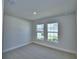 Bright, carpeted bedroom featuring dual windows that let in natural light and neutral paint at 4639 Grandview Glen Dr, Auburndale, FL 33823