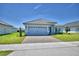Single-story home with well-kept lawn, brick driveway, and gray exterior at 4639 Grandview Glen Dr, Auburndale, FL 33823