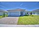 Beautiful single-story home featuring a stone driveway, gray siding, and a well-manicured lawn at 4639 Grandview Glen Dr, Auburndale, FL 33823