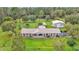 Expansive property featuring a brick home, large lawn, detached garage, and picturesque pond at 9240 Moore Rd, Lakeland, FL 33809
