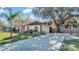 Single story home with red accents and a large front yard at 1555 Archers Path, Lakeland, FL 33809