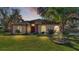 House exterior at dusk with a well-manicured lawn at 1555 Archers Path, Lakeland, FL 33809