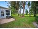 Spacious backyard with lush lawn and mature trees at 202 Golf Aire Blvd, Winter Haven, FL 33884