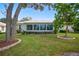 House featuring a large screened-in patio and a well-manicured lawn at 202 Golf Aire Blvd, Winter Haven, FL 33884