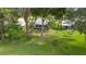 Aerial view of a backyard with lush green lawn, mature trees, and well-maintained landscaping at 202 Golf Aire Blvd, Winter Haven, FL 33884