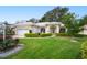 Charming home with a manicured lawn, elegant landscaping, and a two-car garage at 202 Golf Aire Blvd, Winter Haven, FL 33884