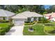Single-story home with tile roof, landscaped yard, and a two-car garage at 202 Golf Aire Blvd, Winter Haven, FL 33884