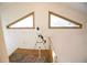 Loft area with hardwood floors and two triangular windows providing natural light at 3597 Raintree Ln, Lakeland, FL 33803
