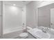 Bright bathroom with a combination tub and shower, white tile, and a vanity with countertop space at 428 Ituna Cir, Winter Haven, FL 33881