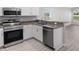 Well-equipped kitchen featuring modern appliances, granite countertops, and sleek gray wood flooring at 428 Ituna Cir, Winter Haven, FL 33881