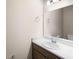 Well-lit powder room with a white sink, wood-tone cabinets, and modern fixtures at 723 Bentley North Loop, Auburndale, FL 33823
