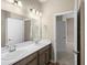 Elegant bathroom with double sinks, ample counter space, and modern lighting fixtures next to bedroom at 723 Bentley North Loop, Auburndale, FL 33823