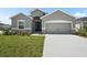 Charming single-story home with a well-manicured lawn, inviting entrance, and attached two-car garage at 723 Bentley North Loop, Auburndale, FL 33823