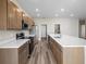 Modern kitchen featuring stainless steel appliances, wooden cabinetry, and a large island with white countertops at 723 Bentley North Loop, Auburndale, FL 33823